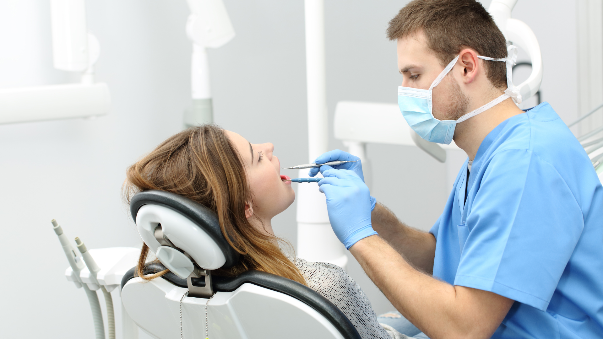Dentist examining a patient's mouth in a dental office.