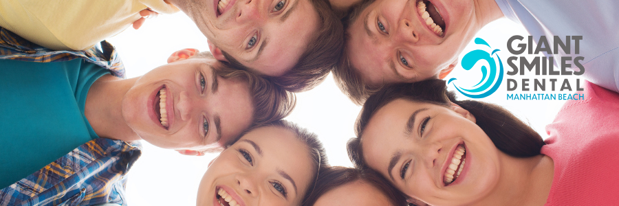 Group of young people smiling, looking down at camera, with the Giant Smiles Dental logo.