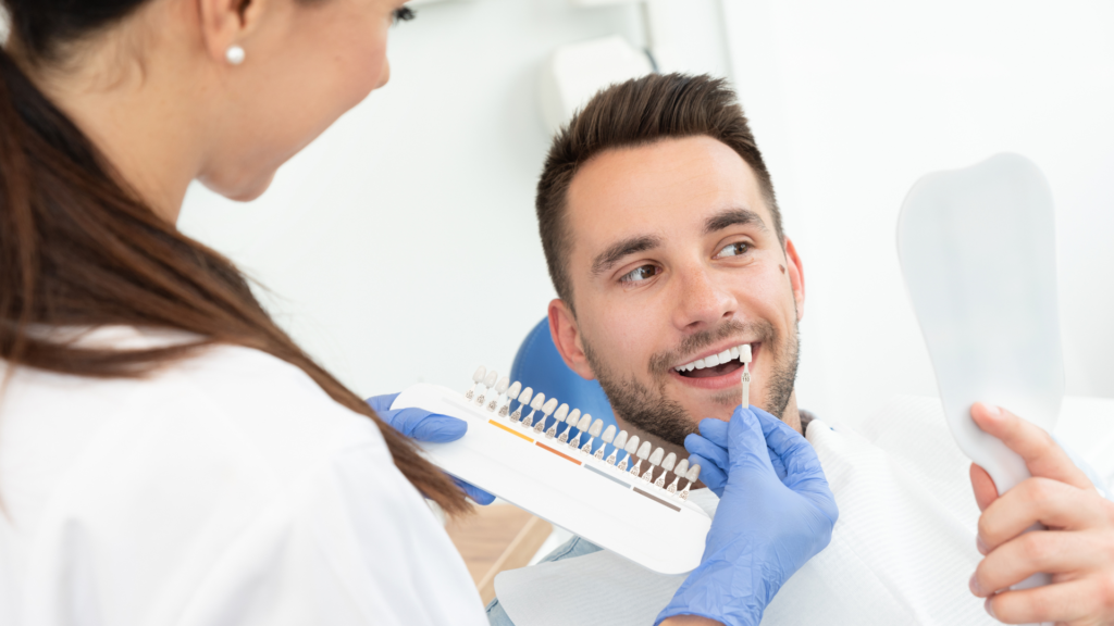 A dentist is examining a man 's teeth in a dental office.