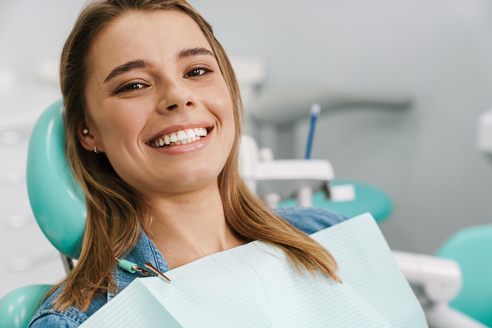 A close up of a person 's teeth with a giant smiles dental logo in the background
