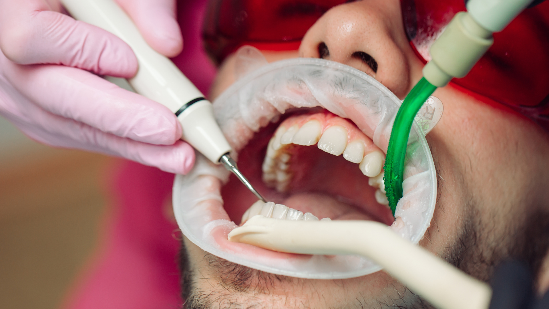 Woman in dental chair, having teeth examined with dental tools, smiling.