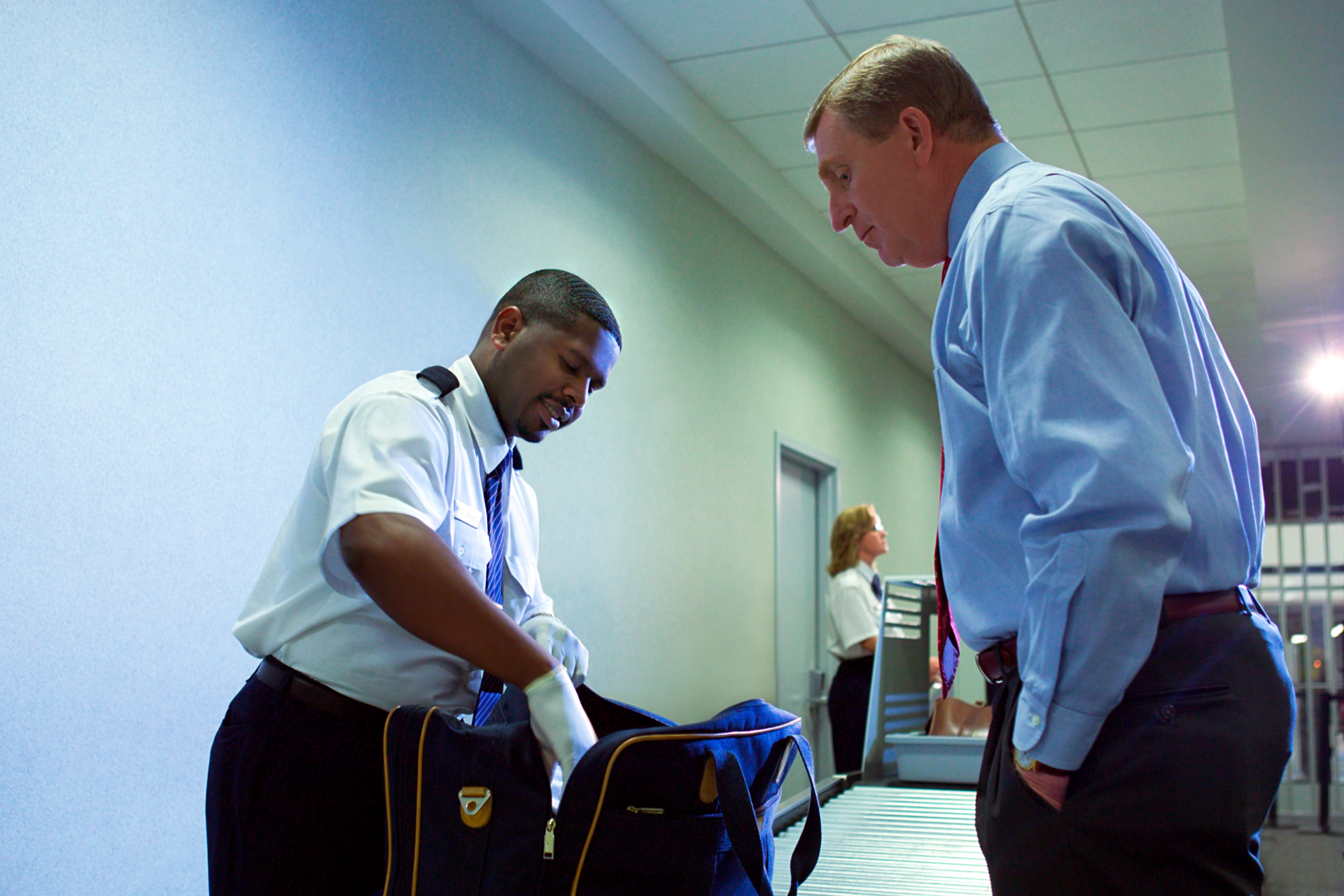 A man in a blue shirt and tie is using a laptop computer.