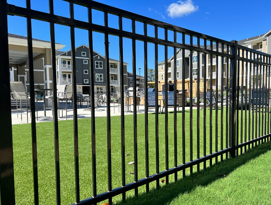 A black metal fence surrounds a construction site.