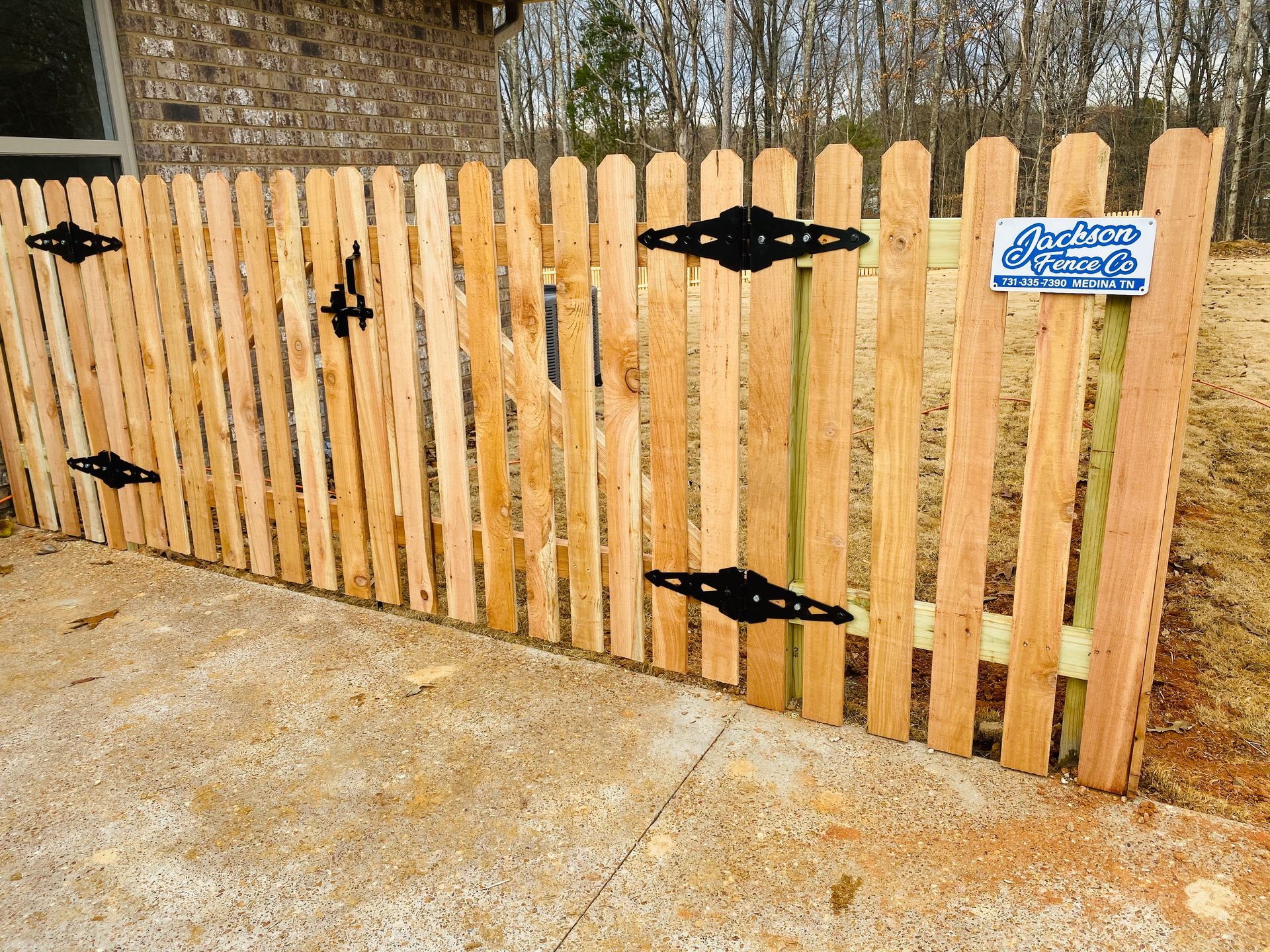 A wooden fence with a sign that says jackson fence on it