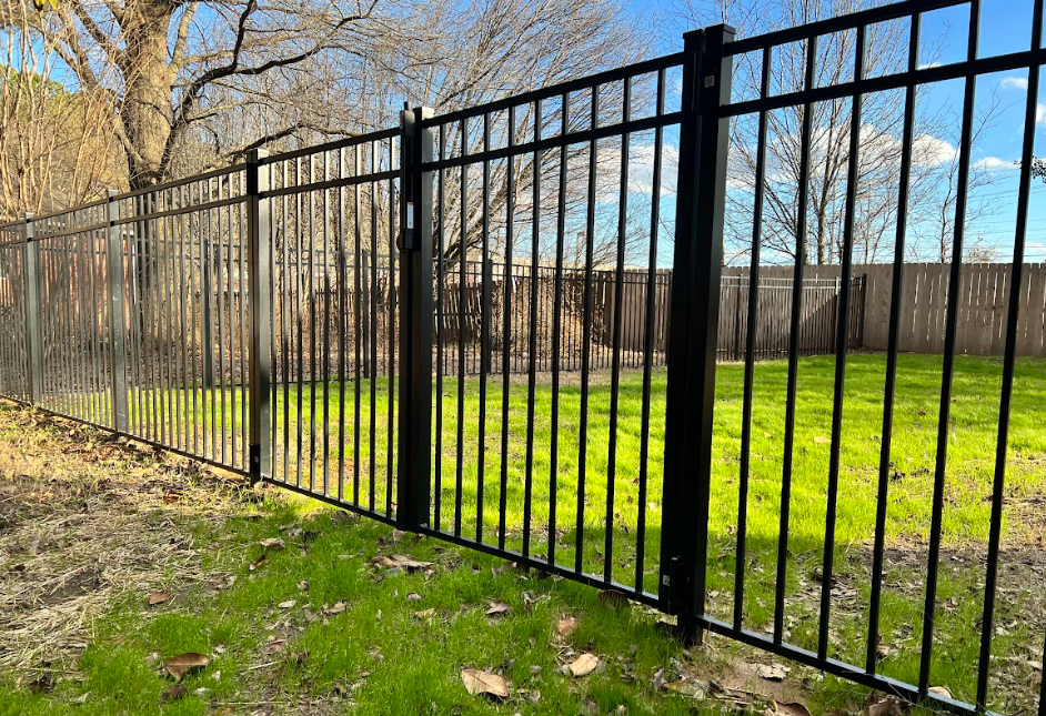 A black metal fence with sharp spikes on a white background.