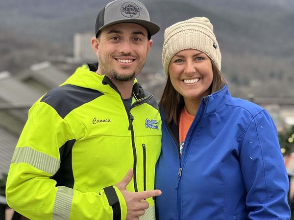 A man and a woman are standing next to each other and smiling for the camera.