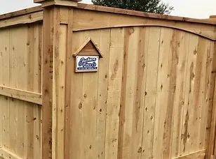 A wooden fence with a birdhouse on top of it.