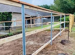 A wooden fence is being built in front of a house.