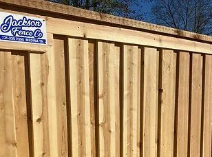 A wooden fence with a jackson fence co. sticker on it.