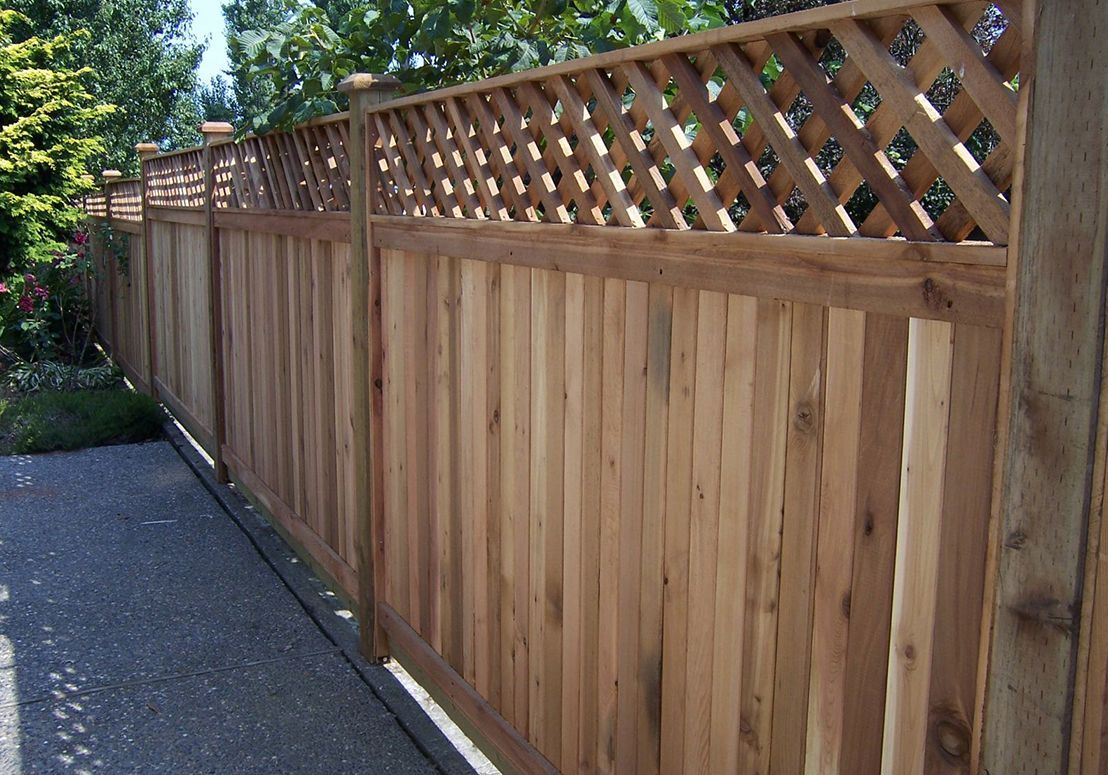 A wooden fence with a lattice on top of it