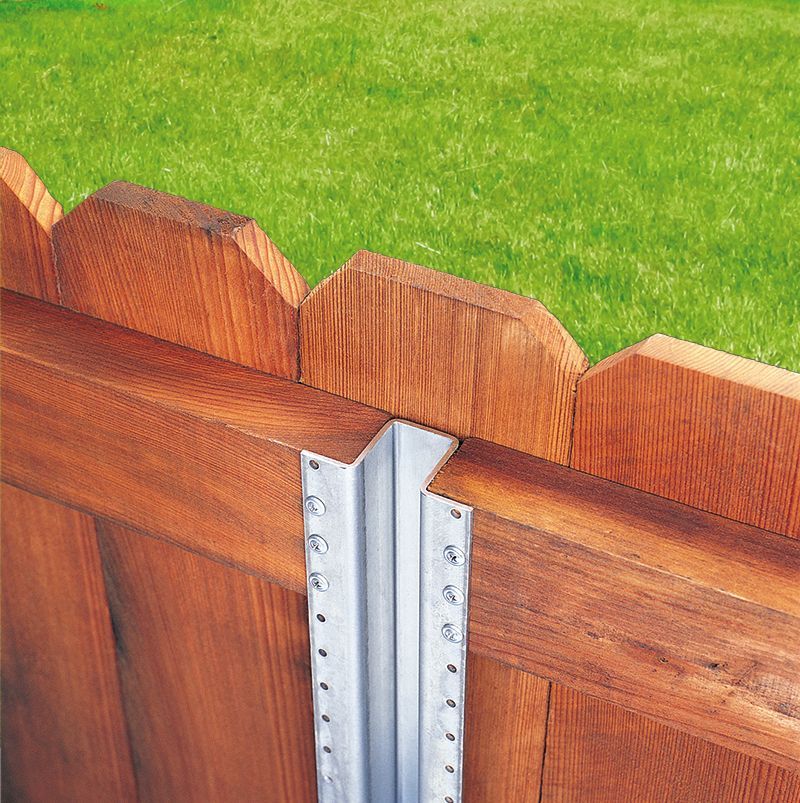 A wooden fence is sitting on top of a lush green lawn.