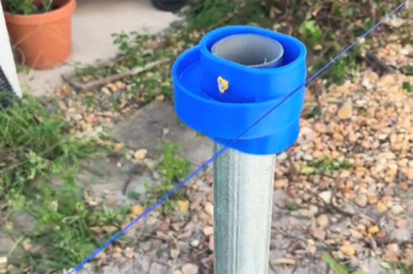 A blue cap is attached to a metal pole.