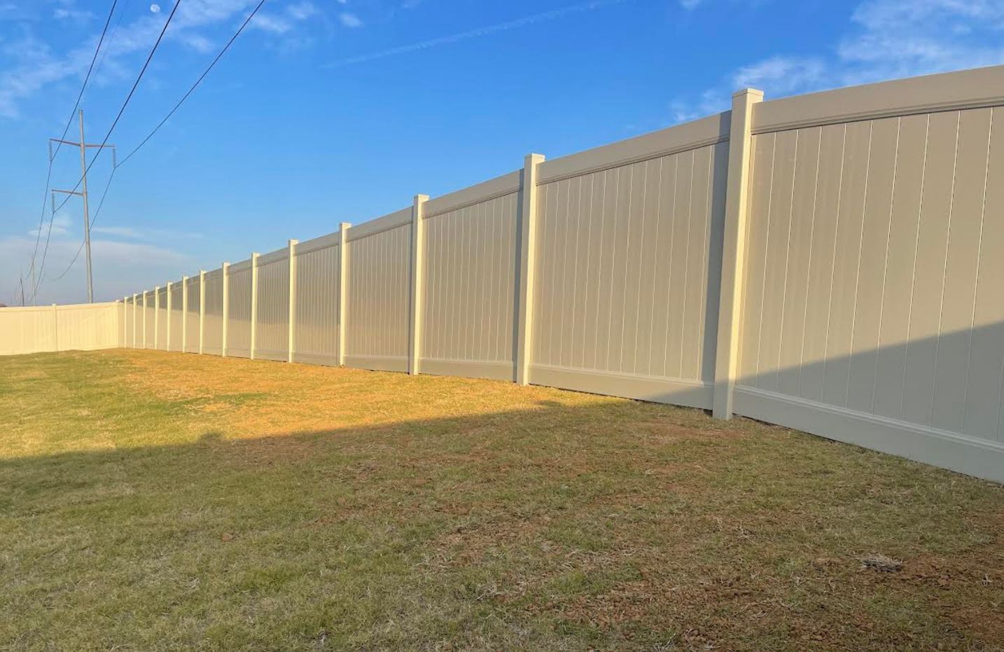 A white fence is sitting in the middle of a grassy field.