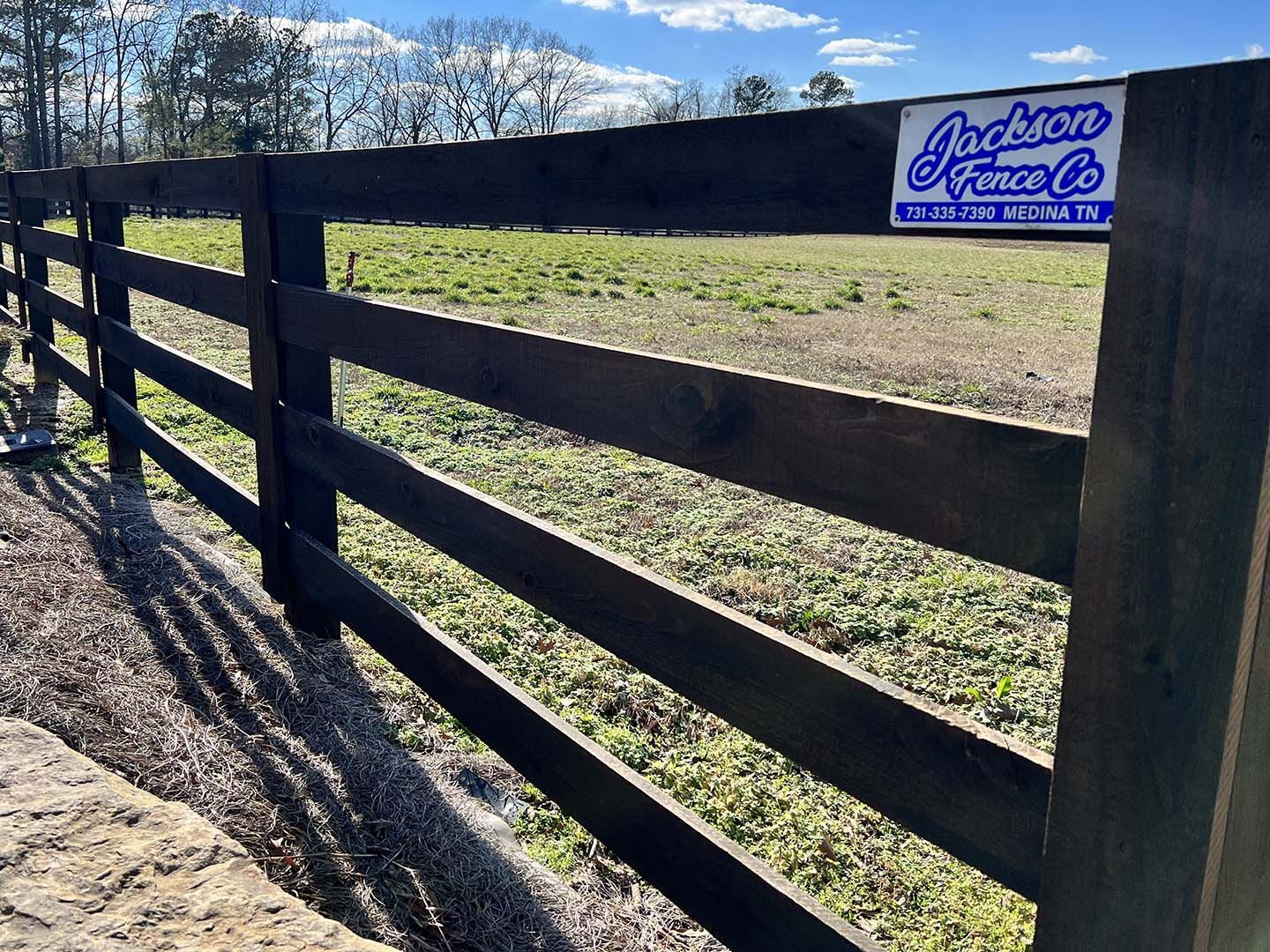A wooden fence with a jackson fence co sticker on it