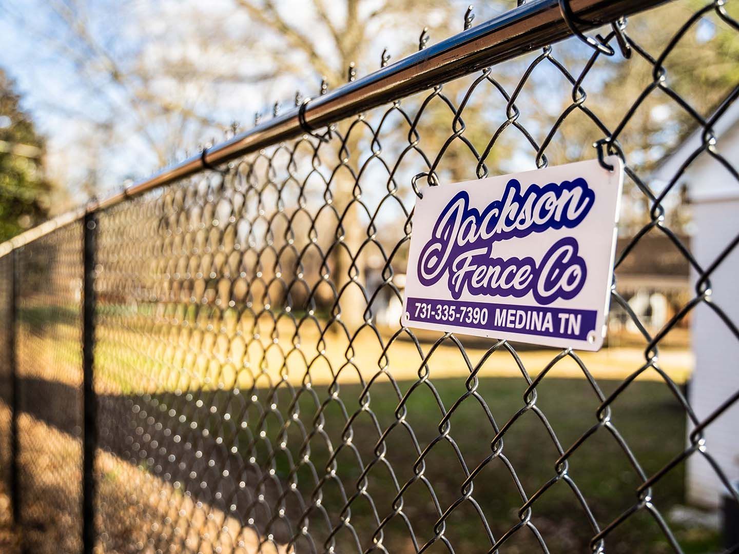 A chain link fence with a sign attached to it.
