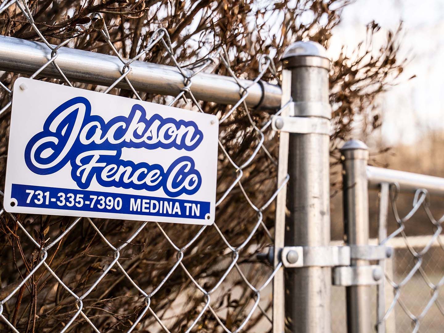 A chain link fence with a sign on it that says jackson fence co.