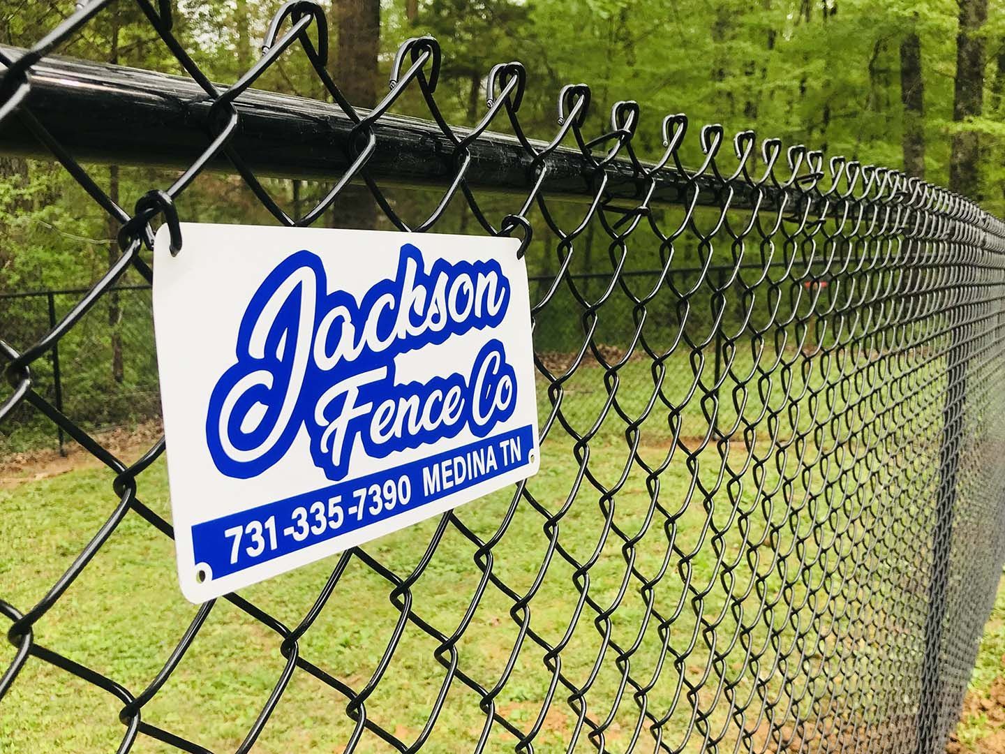 A chain link fence with a sign on it that says jackson fence co.
