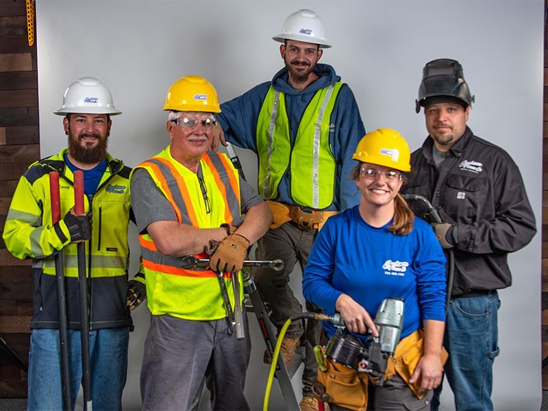 A group of construction workers are posing for a picture.
