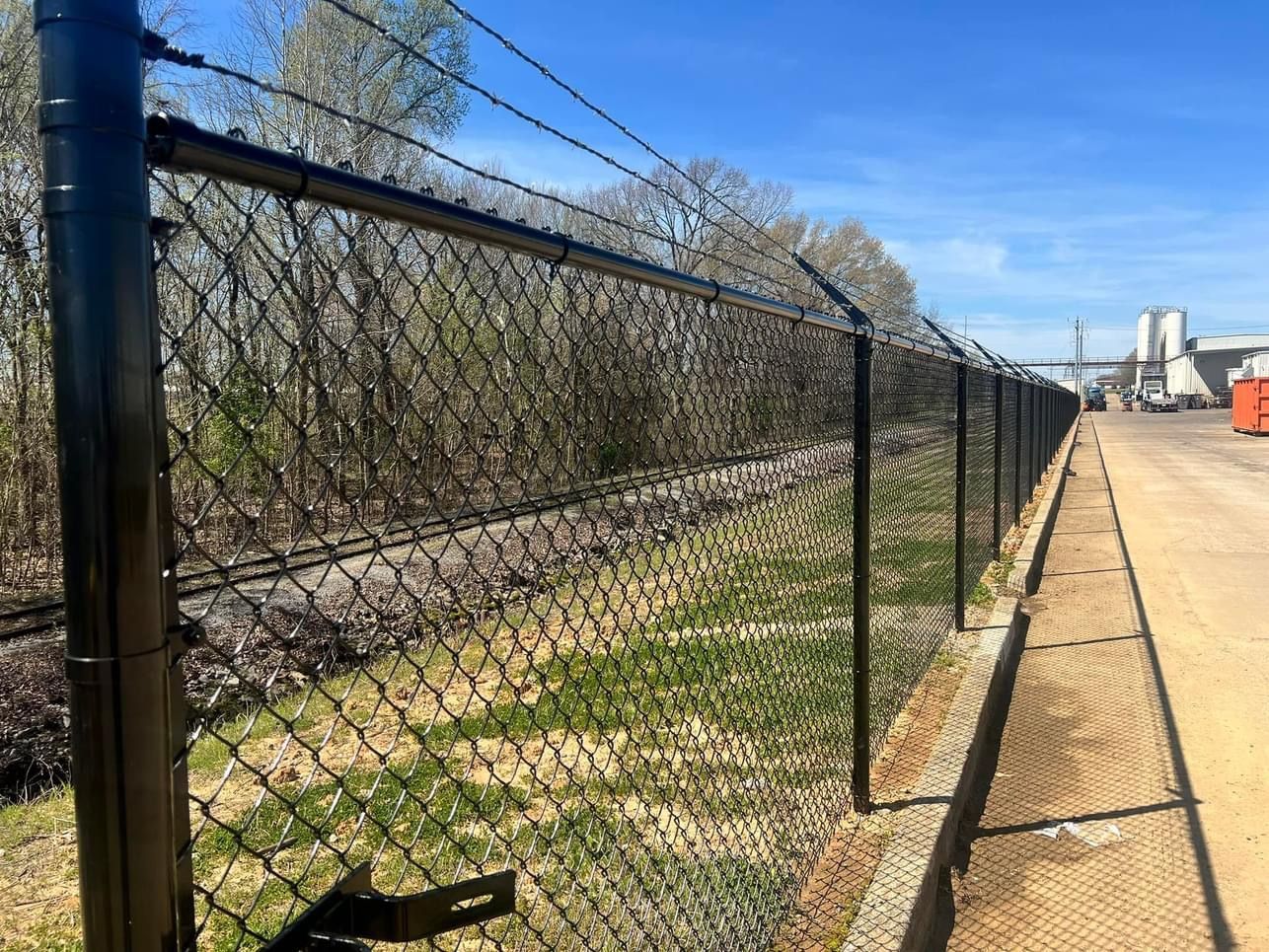 A black metal fence surrounds a construction site.