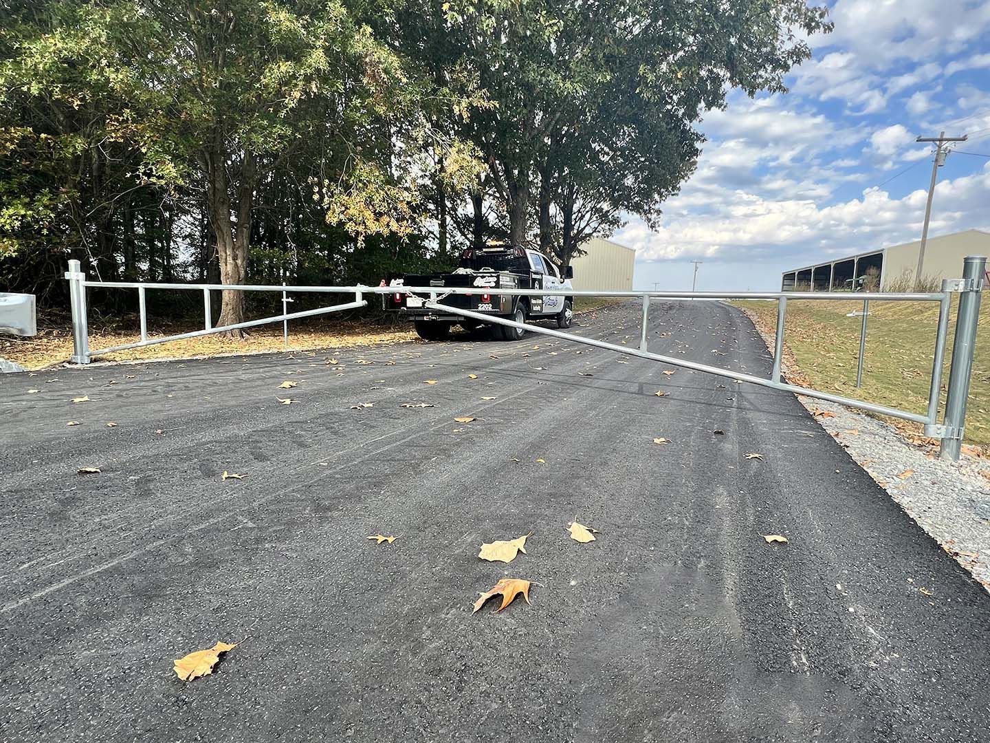 A car is parked in a parking lot next to a fence.