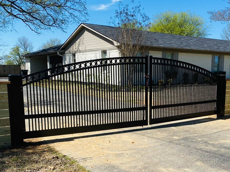 A black gate is open in front of a house