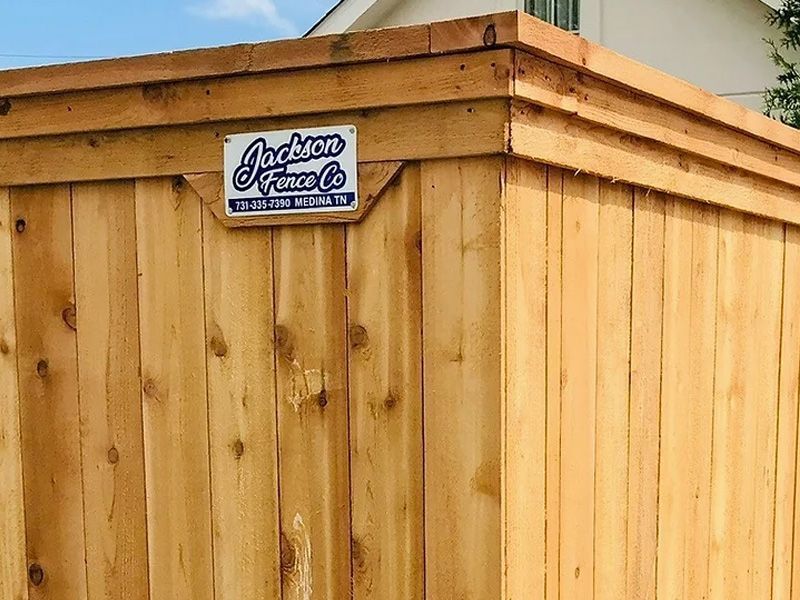 A wooden fence with a sign on it that says jackson fence co.