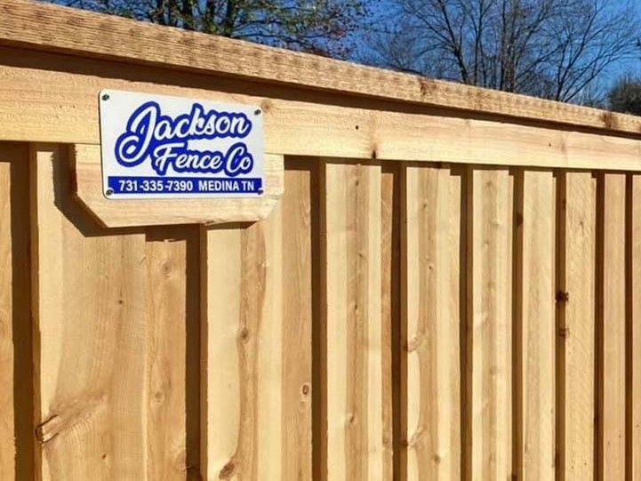 A wooden fence with a sign on it that says jackson fence co.