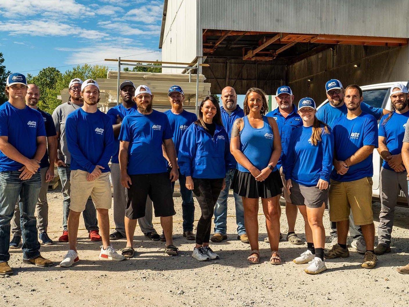 A group of people in blue shirts are posing for a picture.