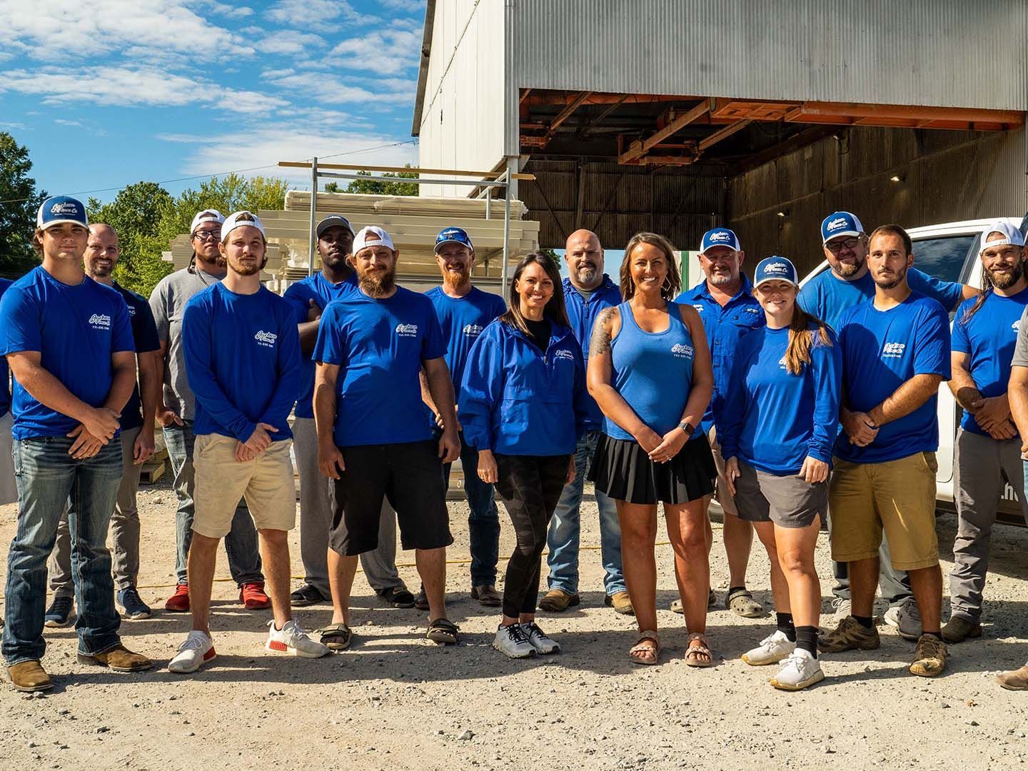 A group of people in blue shirts are posing for a picture.
