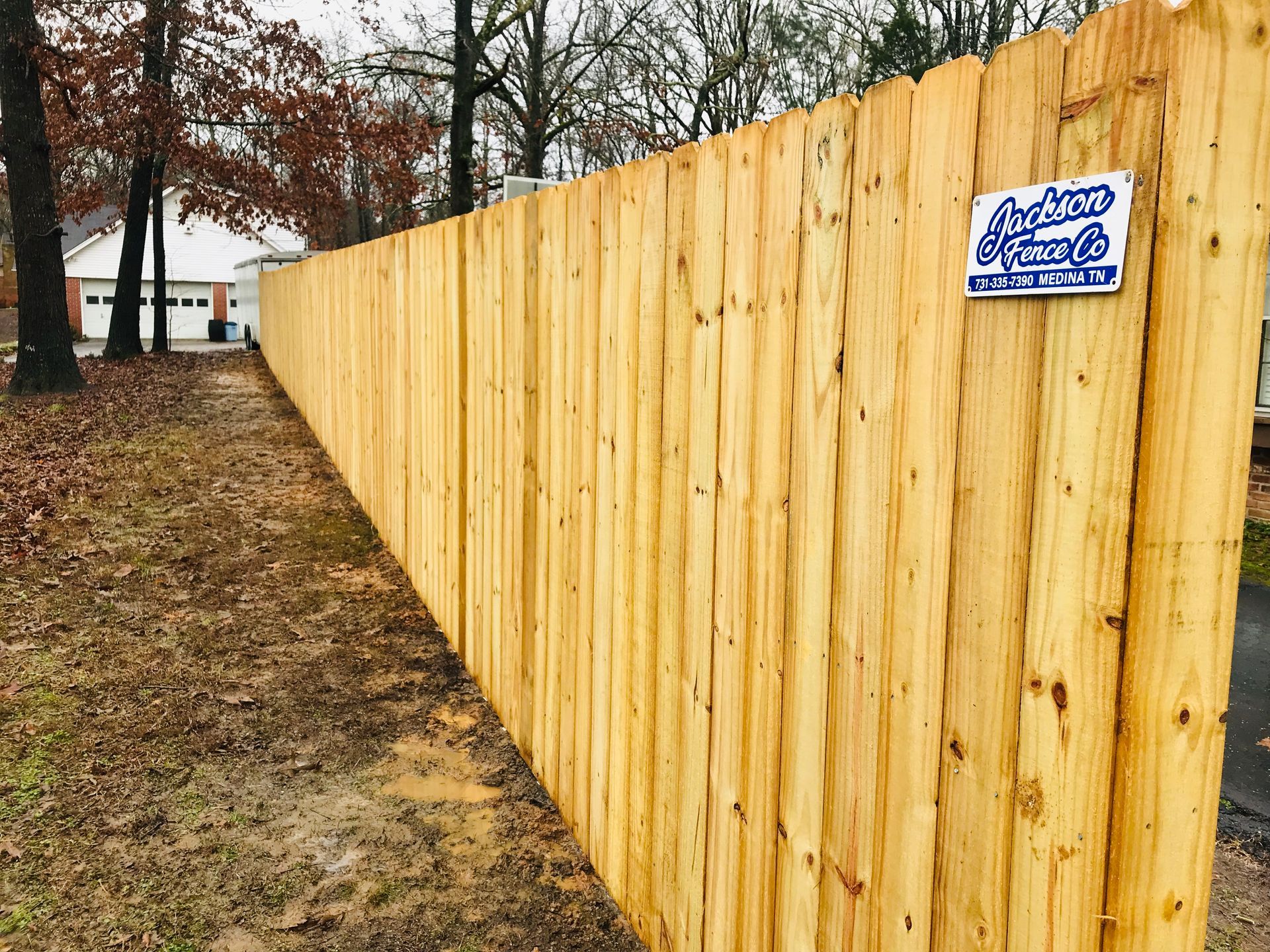 A wooden fence with a sign attached to it.