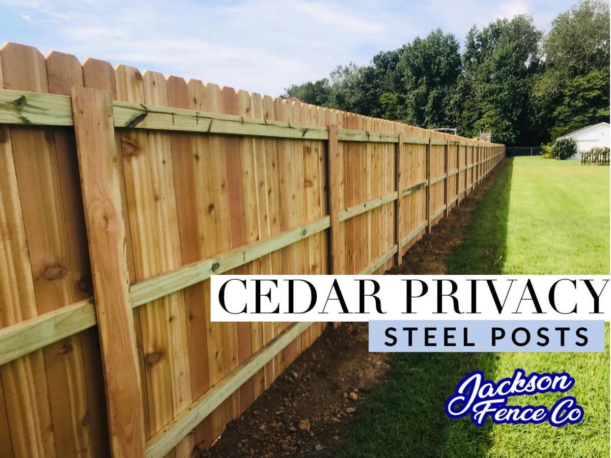 A cedar privacy fence with steel posts in a backyard