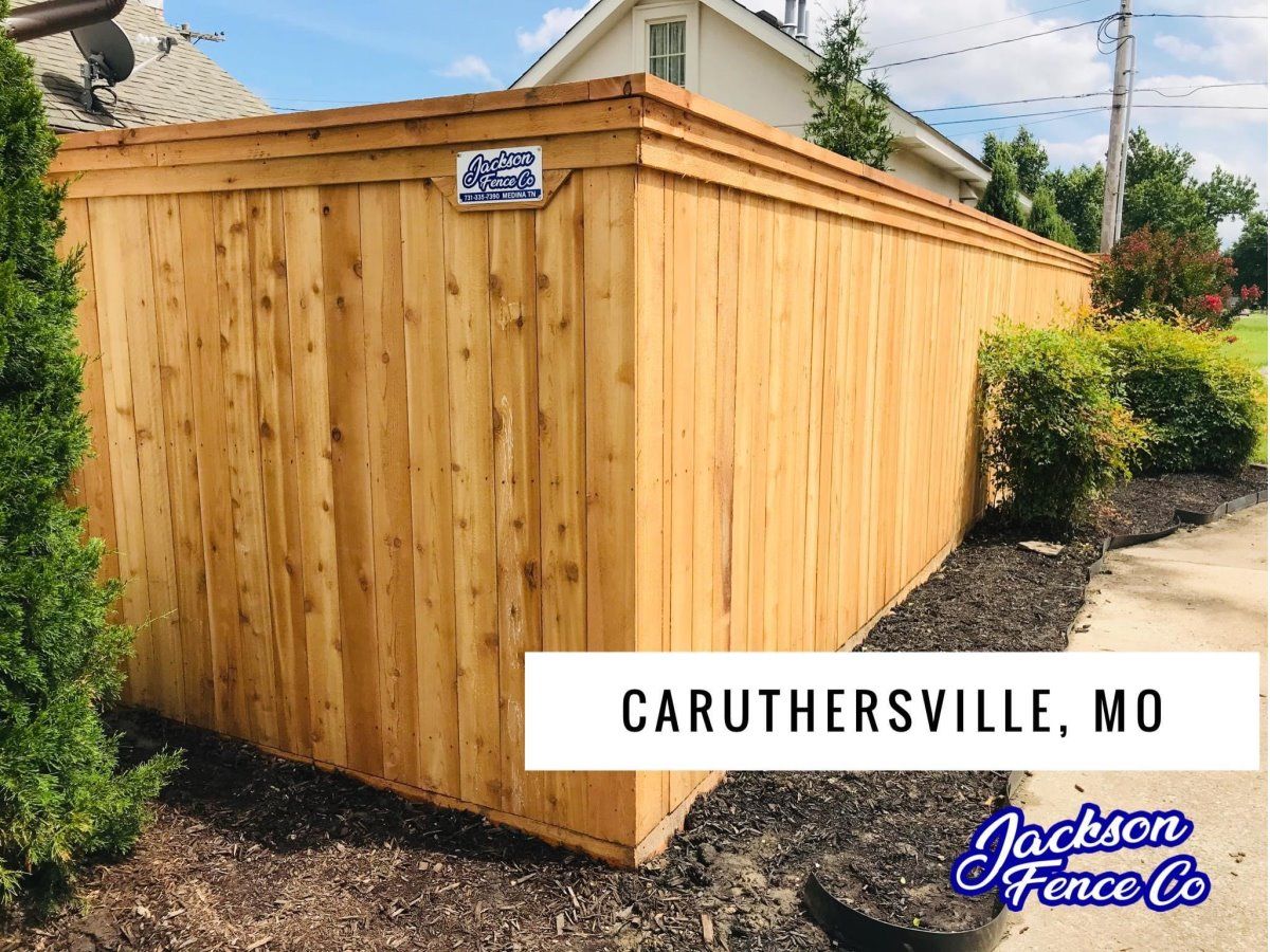 A wooden fence is sitting in front of a house in caruthersville , mo.