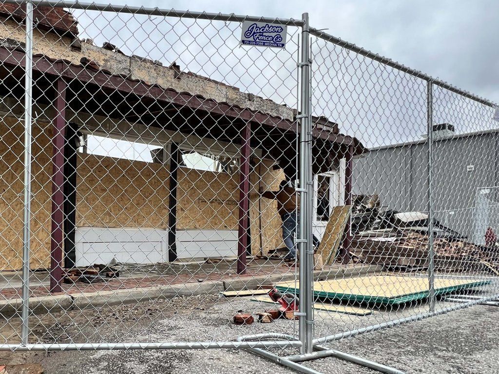 A chain link fence is surrounding a building under construction.