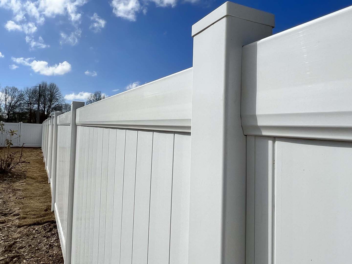 A white fence with a blue sky in the background.