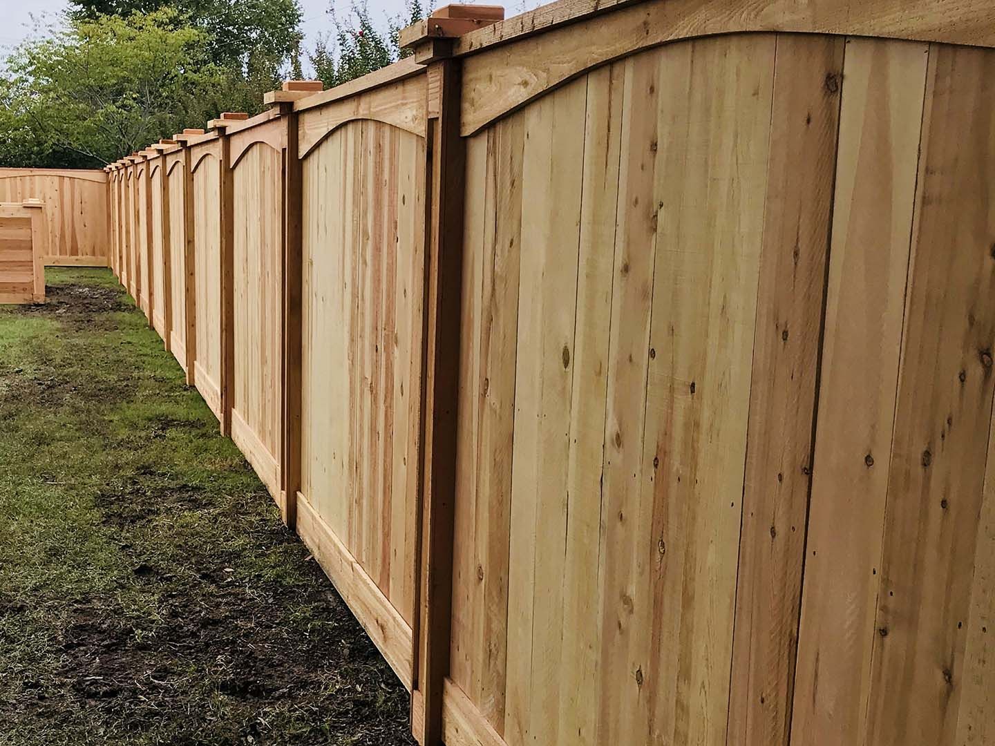 A wooden fence is sitting on top of a lush green field.