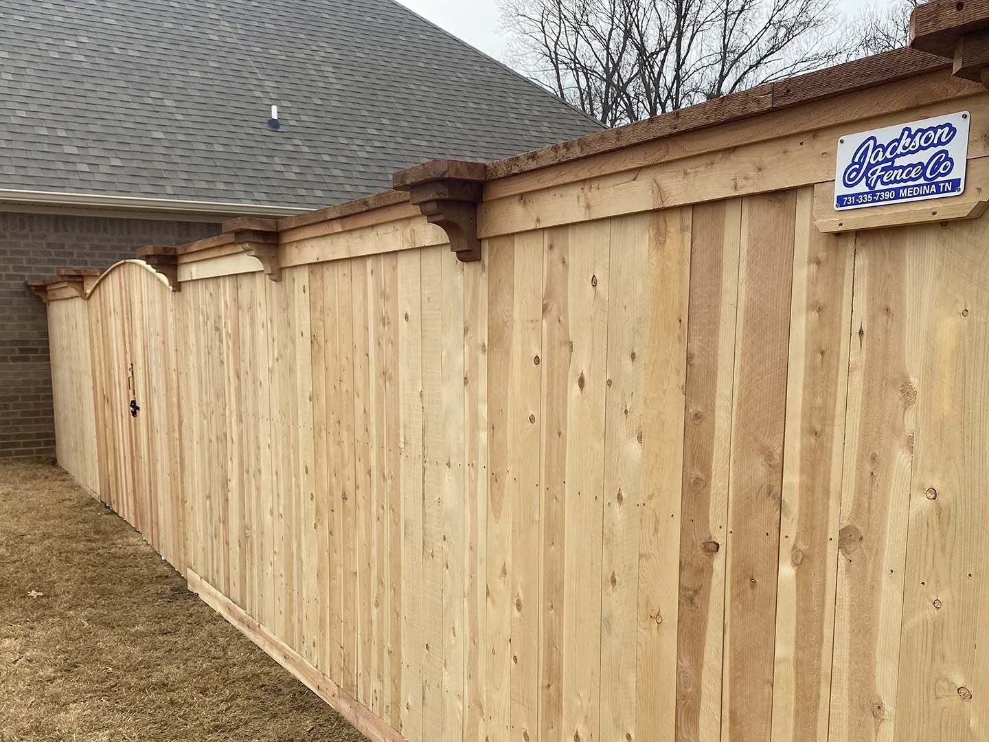 A wooden fence is sitting in front of a house.
