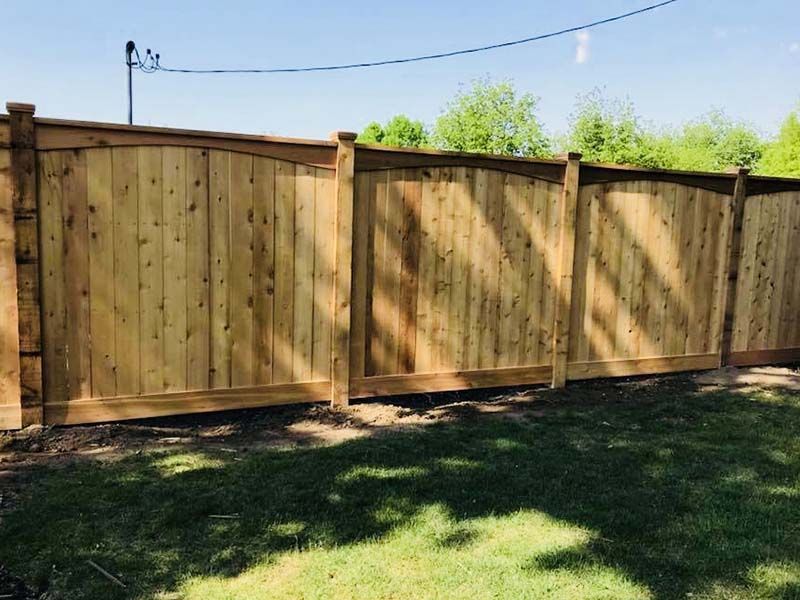 A wooden fence is sitting in the middle of a lush green field.