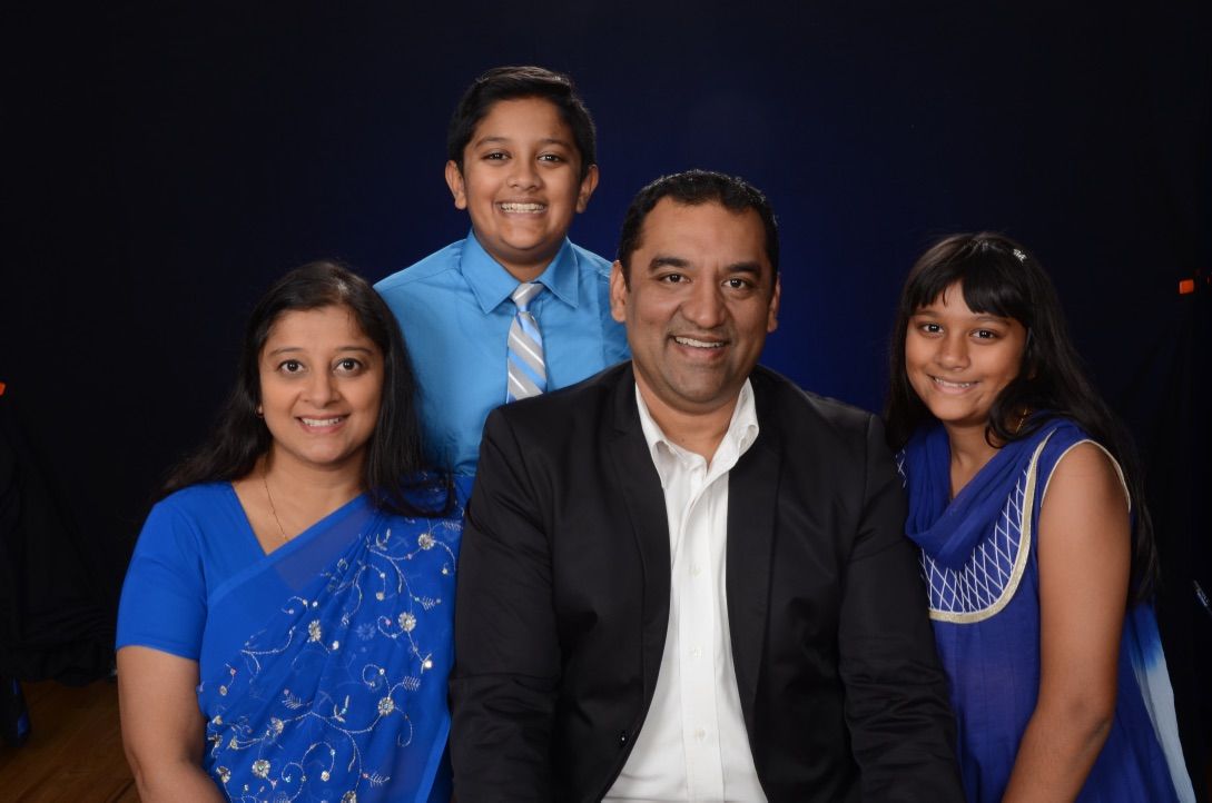 A family posing for a picture with a blue background
