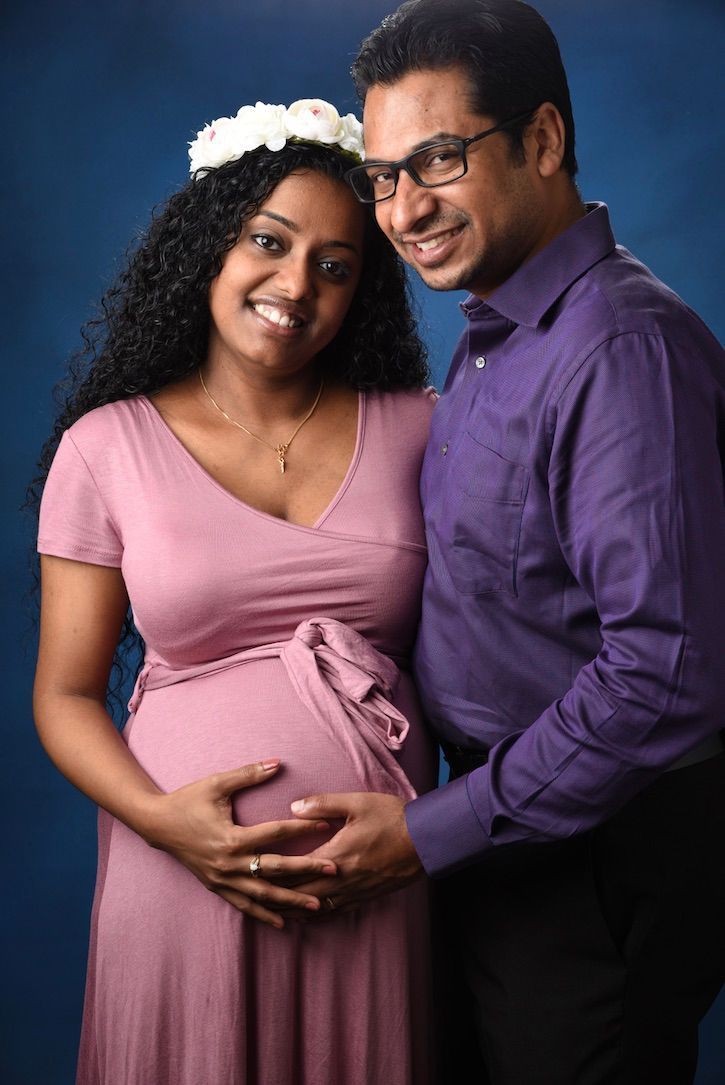 A man and a pregnant woman are posing for a picture.
