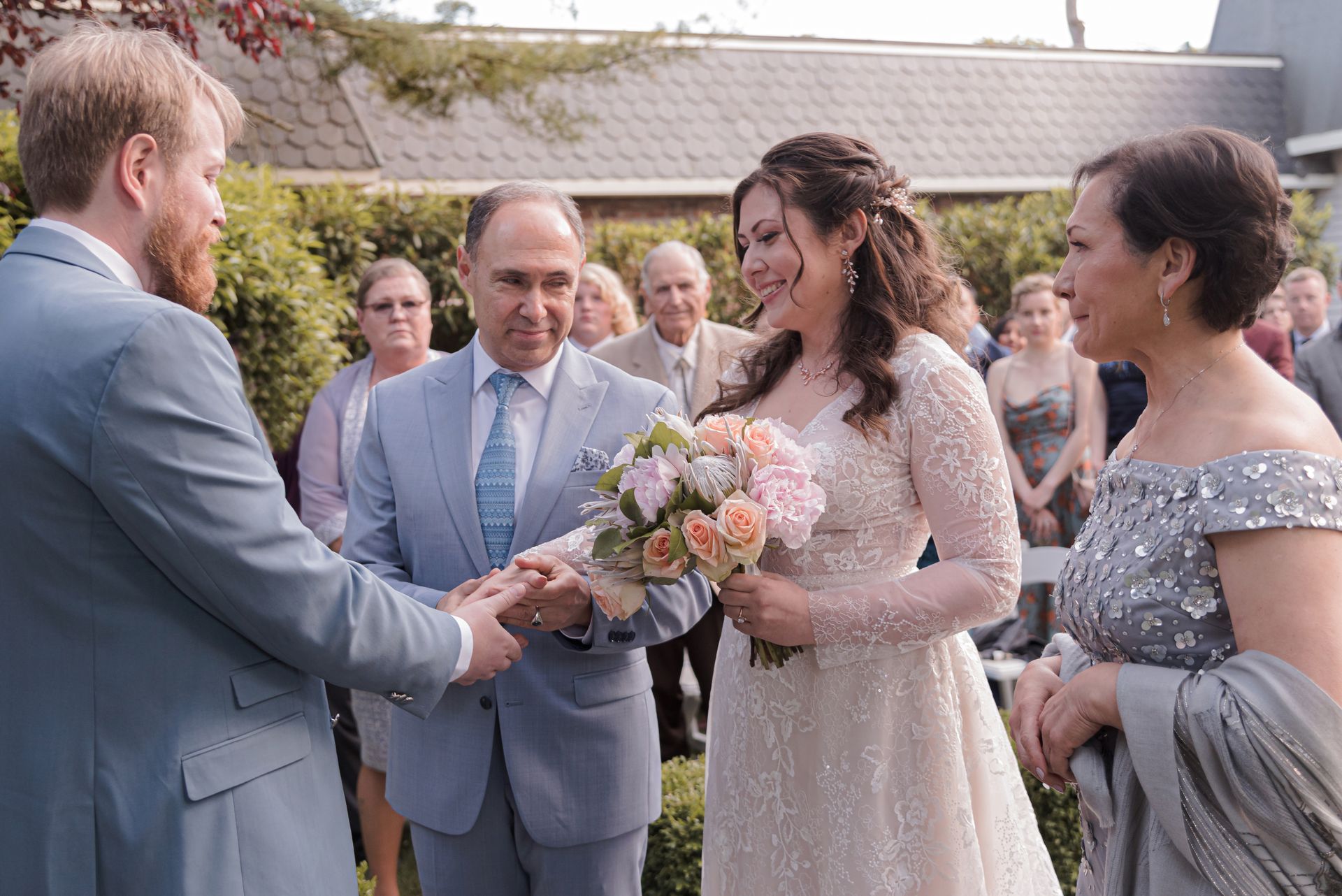 A bride and groom are holding hands during their wedding ceremony.