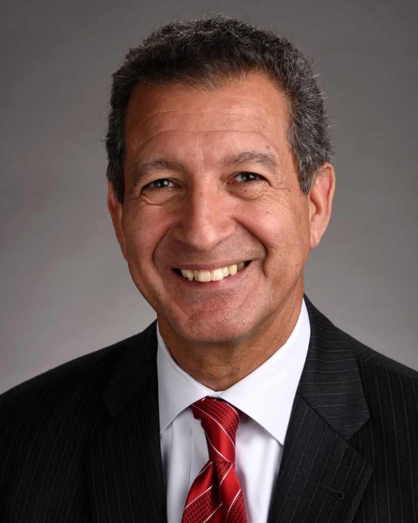 A man in a suit and tie is smiling for the camera.