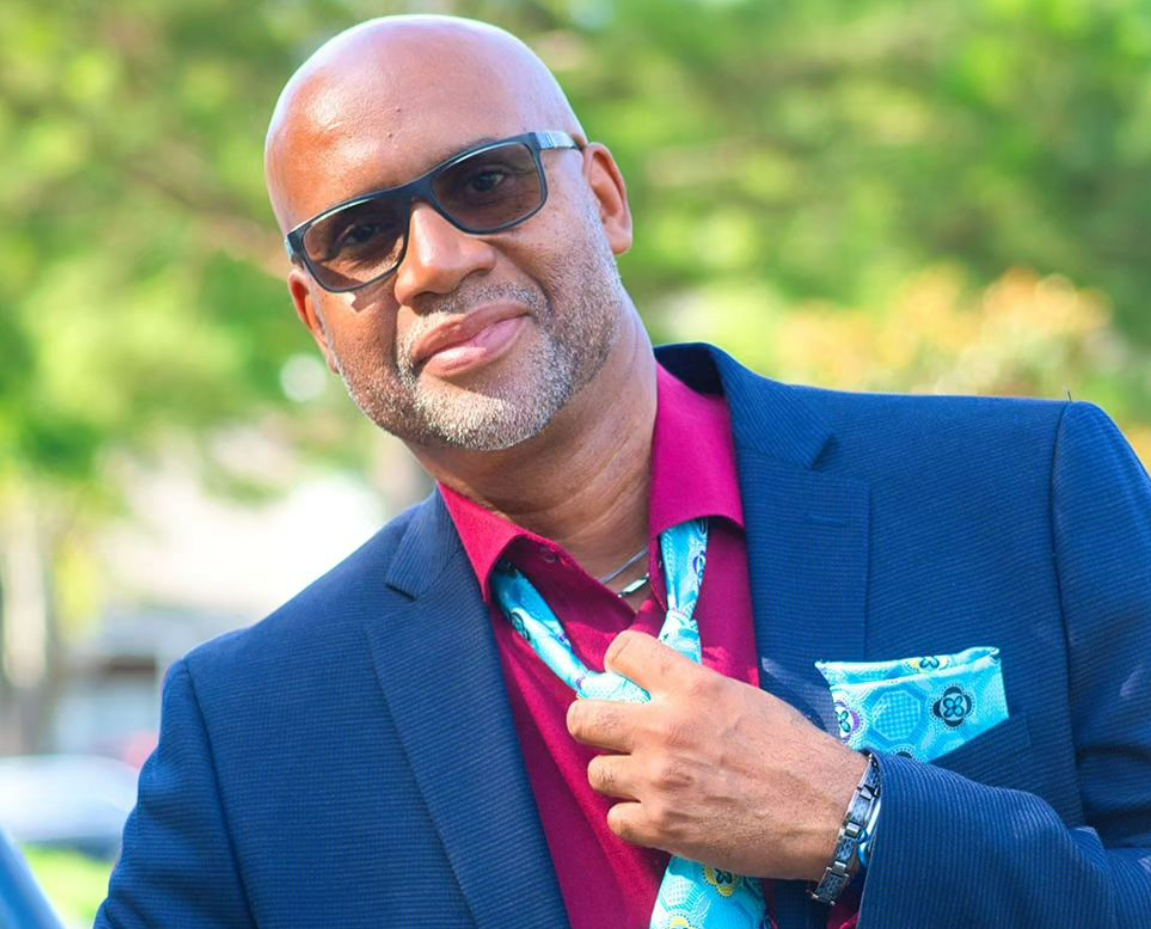 A man in a suit and tie is adjusting his tie