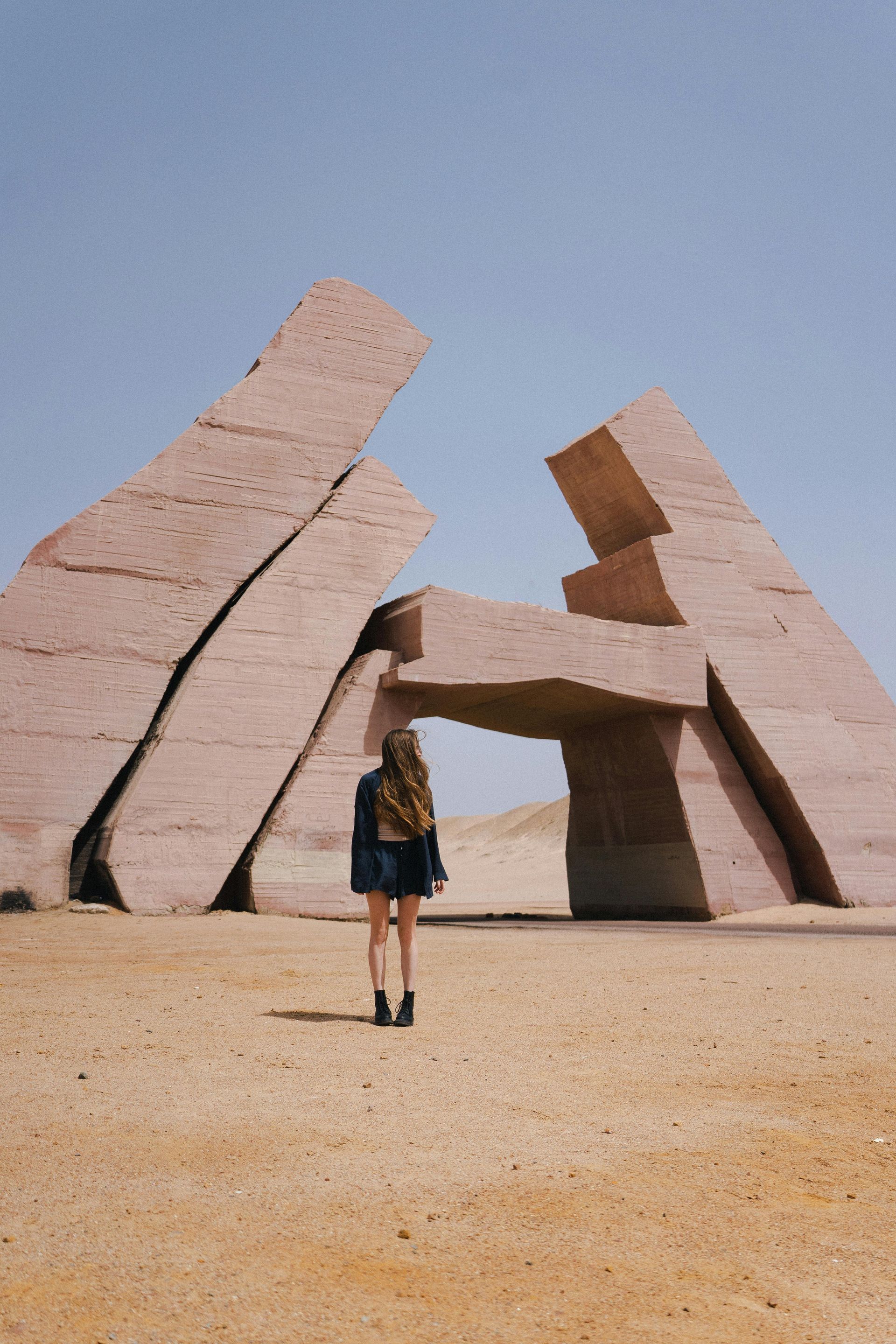 Wooden boat in turquoise water, harbor with white yachts and buildings in background.