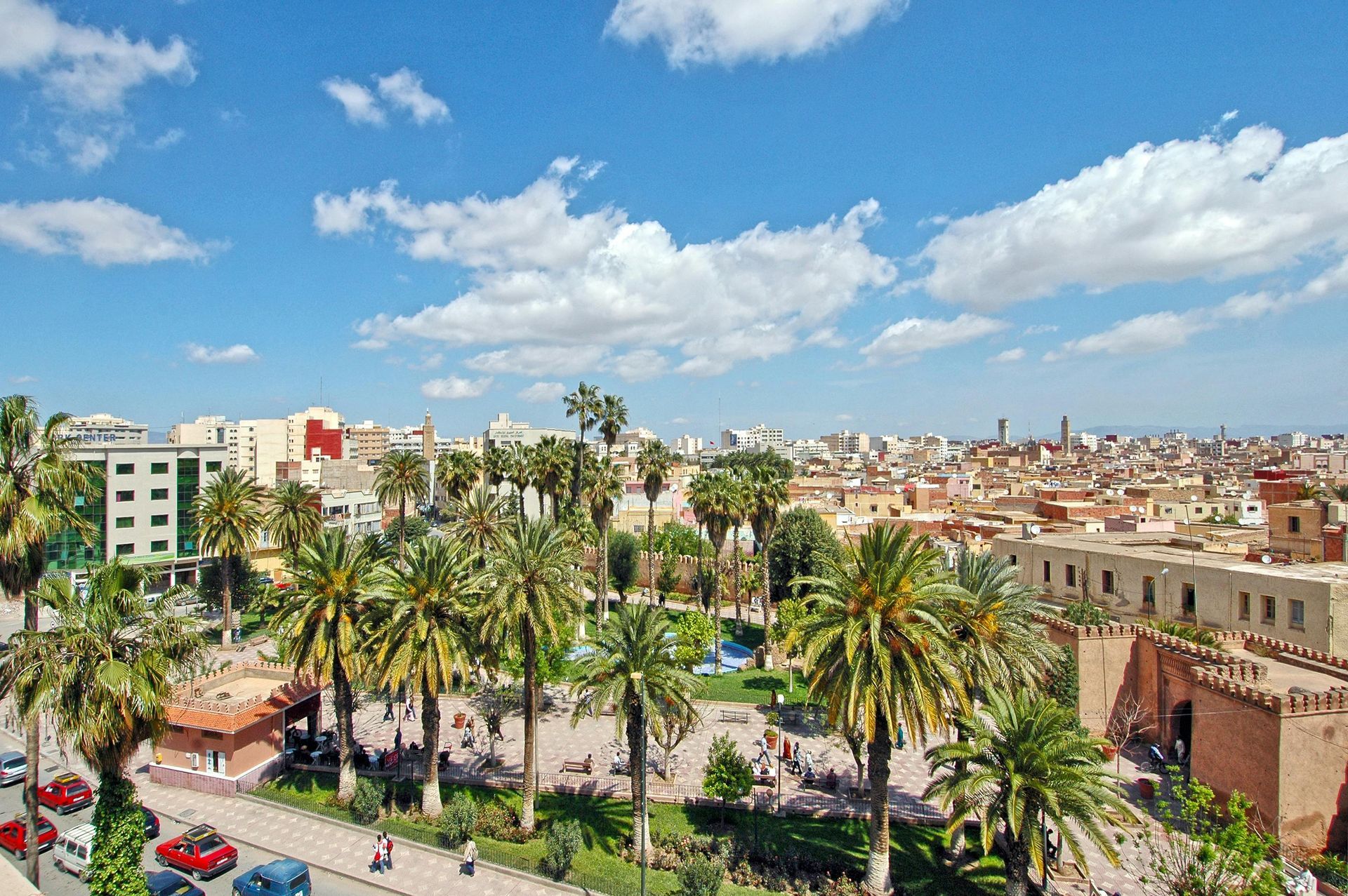 Mosque illuminated at night, dome and minaret aglow, arched entrance, warm colors, stone structure.