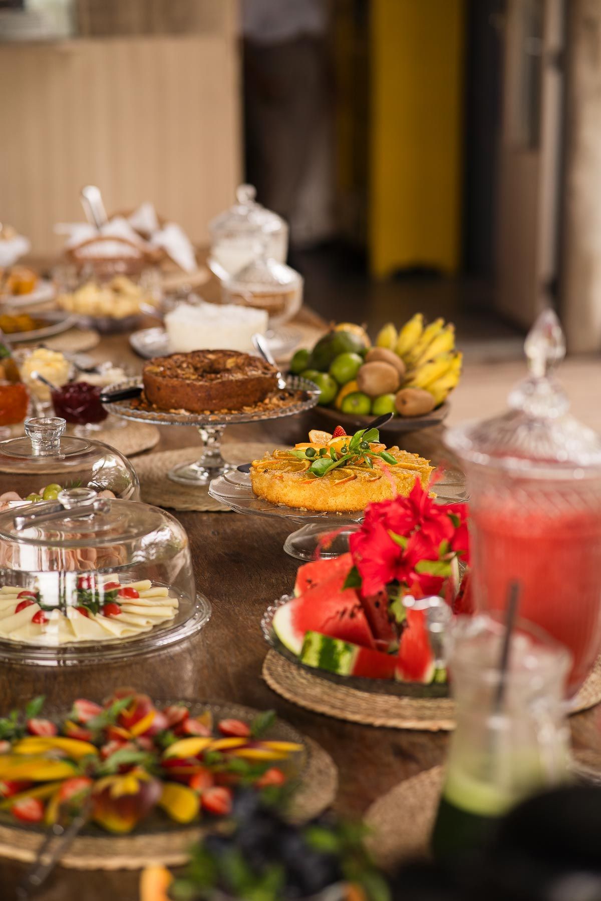 Vista do pôr do sol sobre uma floresta exuberante da borda da piscina; céu laranja e roxo.