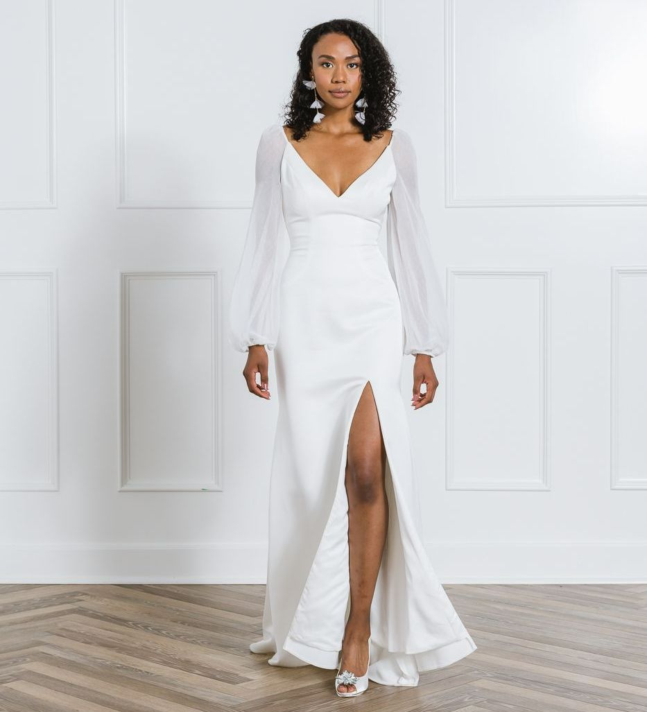 Modern crepe fit and flare with a wide v-neck. Chiffon bishop sleeves. Sexy slit above the left leg.