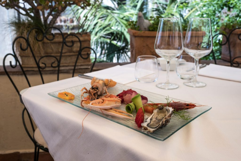Un piatto di cibo e bicchieri di vino su un tavolo.