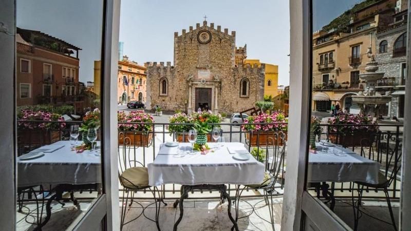 Un balcone con tavolo e sedie e vista sulla chiesa.