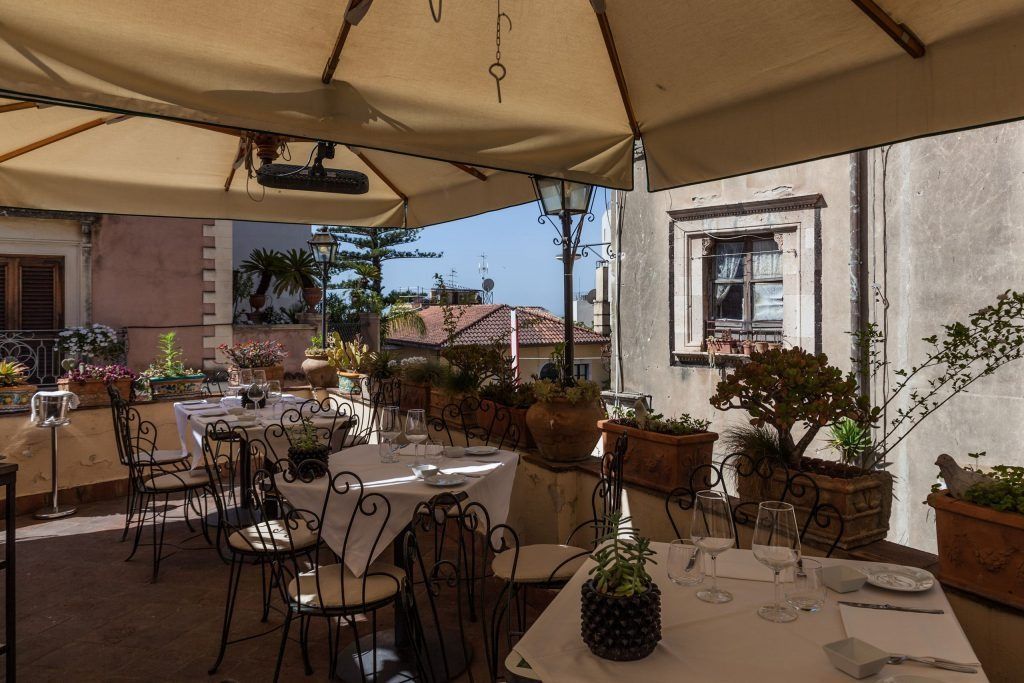 Un ristorante con tavoli e sedie sotto un ombrellone