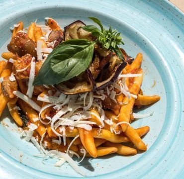 Un piatto blu con patatine fritte e verdure